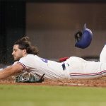
              Texas Rangers Josh Smith slides safely into home plate for an inside-the-park home run during the sixth inning of a baseball game against the Oakland Athletics in Arlington, Texas, Monday, July 11, 2022. Rangers' Leody Taveras also scored on the play. (AP Photo/LM Otero)
            