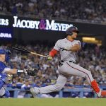 
              Washington Nationals' Juan Soto, right, hits a two RBI triple as Los Angeles Dodgers catcher Will Smith watches during the fifth inning of a baseball game Monday, July 25, 2022, in Los Angeles. (AP Photo/Mark J. Terrill)
            