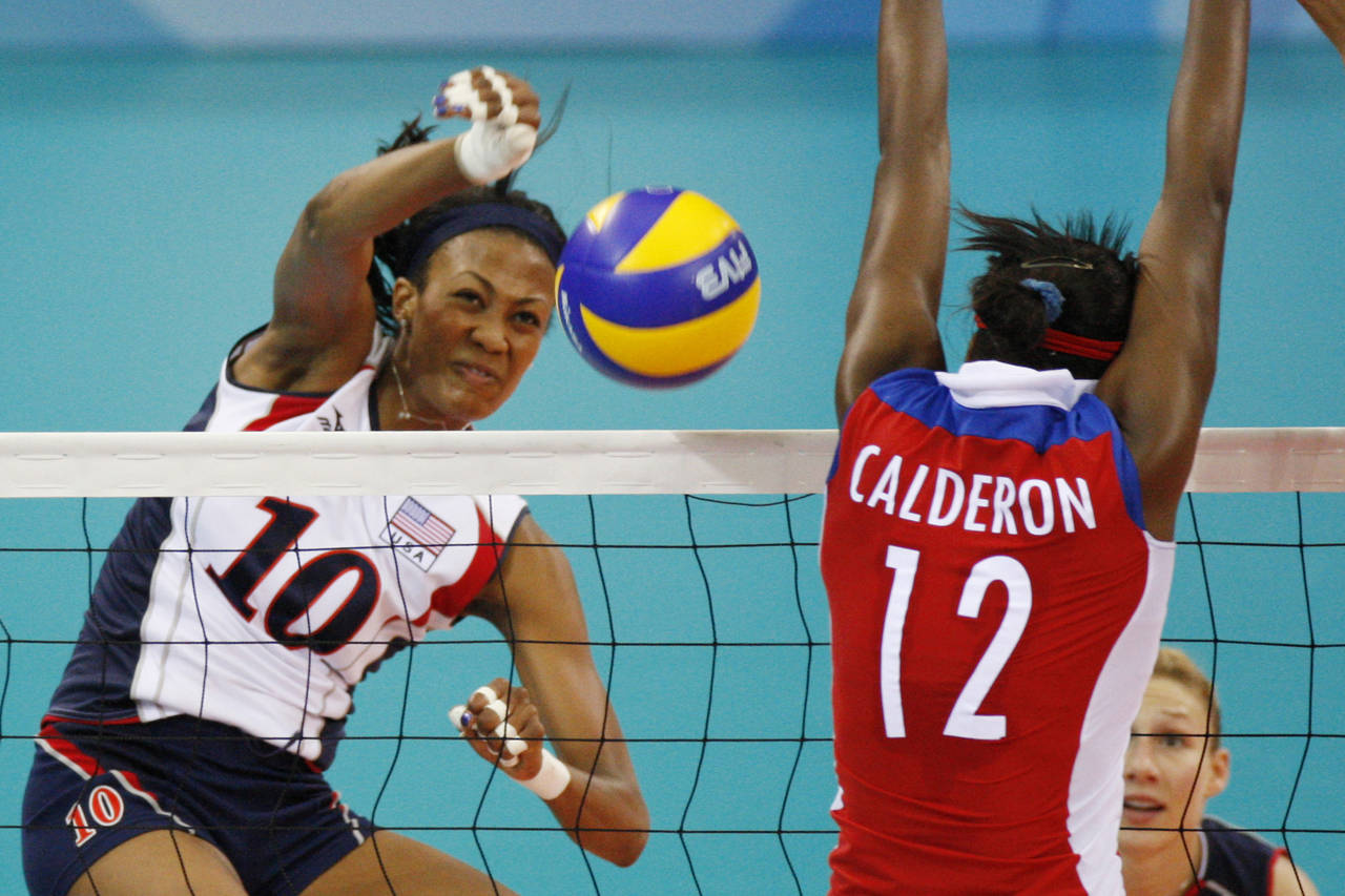 FILE - USA's Kim Glass, left, jumps for the ball with Cuba wing spiker Rosir Calderon during a wome...
