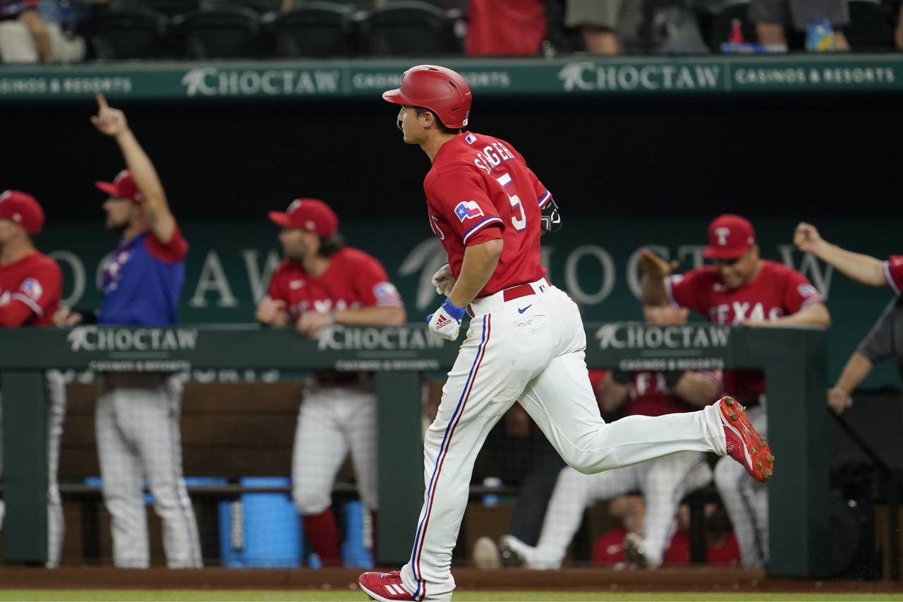 The dugout celebrates as Texas Rangers' Corey Seager (5) reuns the bases after hitting a three-run ...