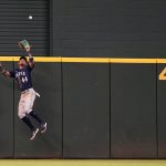
              Seattle Mariners center fielder Julio Rodriguez (44) jumps to catch a fly out at the wall against Texas Rangers Adolis Garcia during the second inning of a baseball game in Arlington, Texas, Sunday, July 17, 2022. (AP Photo/LM Otero)
            