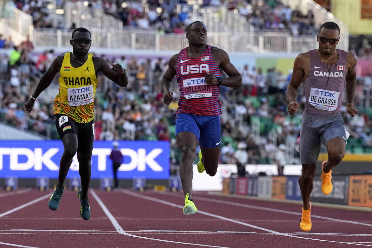 Christian Coleman, center, of the United States, wins a heat in the men's 100-meter run at the Worl...