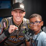 
              This July 1, 2022 photo provided by LakeSide Media shows NASCAR driver Brandon Brown, left, posing with eight-year-old Brandon Brundidge of Cottage Grove, Minn., in person for the first time this weekend at Road America in Elkhart Lake, Wis. The hood of Brown’s Camaro for his Xfinity Series race Saturday at Road America featured the cover design of “Brandon Spots His Sign,” a children’s book written by Brundidge’s mother, Sheletta Brundidge. (Garrett Pace/LakeSide Media via AP)
            