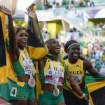 
              Gold medalist Shelly-Ann Fraser-Pryce, of Jamaica, center, stands with silver medalist Shericka Jackson, of Jamaica, right, and bronze medalist Elaine Thompson-Herah, of Jamaica, wave after a medal ceremony for the final in the women's 100-meter run at the World Athletics Championships on Sunday, July 17, 2022, in Eugene, Ore. (AP Photo/Ashley Landis)
            