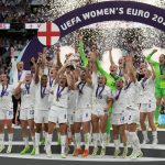 
              England's Leah Williamson, center left, and Millie Bright lift the trophy after winning the Women's Euro 2022 final soccer match between England and Germany at Wembley stadium in London, Sunday, July 31, 2022. England won 2-1. (AP Photo/Alessandra Tarantino)
            