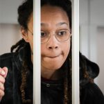 
              WNBA star and two-time Olympic gold medalist Brittney Griner speaks to her lawyers standing in a cage at a court room prior to a hearing, in Khimki just outside Moscow, Russia, Tuesday, July 26, 2022. American basketball star Brittney Griner returns Tuesday to a Russian courtroom for her drawn-out trial on drug charges that could bring her 10 years in prison of convicted. (AP Photo/Alexander Zemlianichenko, Pool)
            