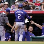 
              Texas Rangers' Marcus Semien is congratulated by teammates in the dugout after scoring on a single by Nathaniel Lowe during the first inning of a baseball game against the Los Angeles Angels Sunday, July 31, 2022, in Anaheim, Calif. (AP Photo/Mark J. Terrill)
            