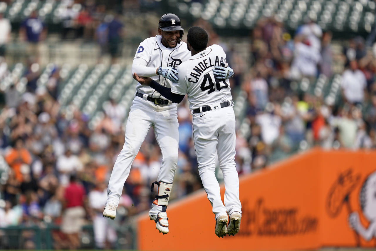 Detroit Tigers' Victor Reyes, left, celebrates his two-run double with Jeimer Candelario (46) again...