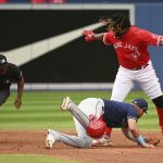 
              Toronto Blue Jays Vladimir Guerrero Jr, right, reacts after sliding safely into into second base for a two-run double ahead of a tag by Tampa Bay Rays' second baseman Isaac Paredes in the of a baseball game in Toronto on Friday July 1, 2022. (Jon Blacker/The Canadian Press via AP)
            