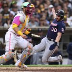 
              Minnesota Twins' Kyle Garlick, right, scores on a single by Jose Miranda as San Diego Padres catcher Austin Nola waits for the throw during the eighth inning of a baseball game Saturday, July 30, 2022, in San Diego. (AP Photo/Derrick Tuskan)
            