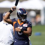 
              Denver Broncos quarterback Russell Wilson warms up during the opening session of the NFL football team's training camp Wednesday, July 27, 2022, in Centennial, Colo. (AP Photo/David Zalubowski)
            