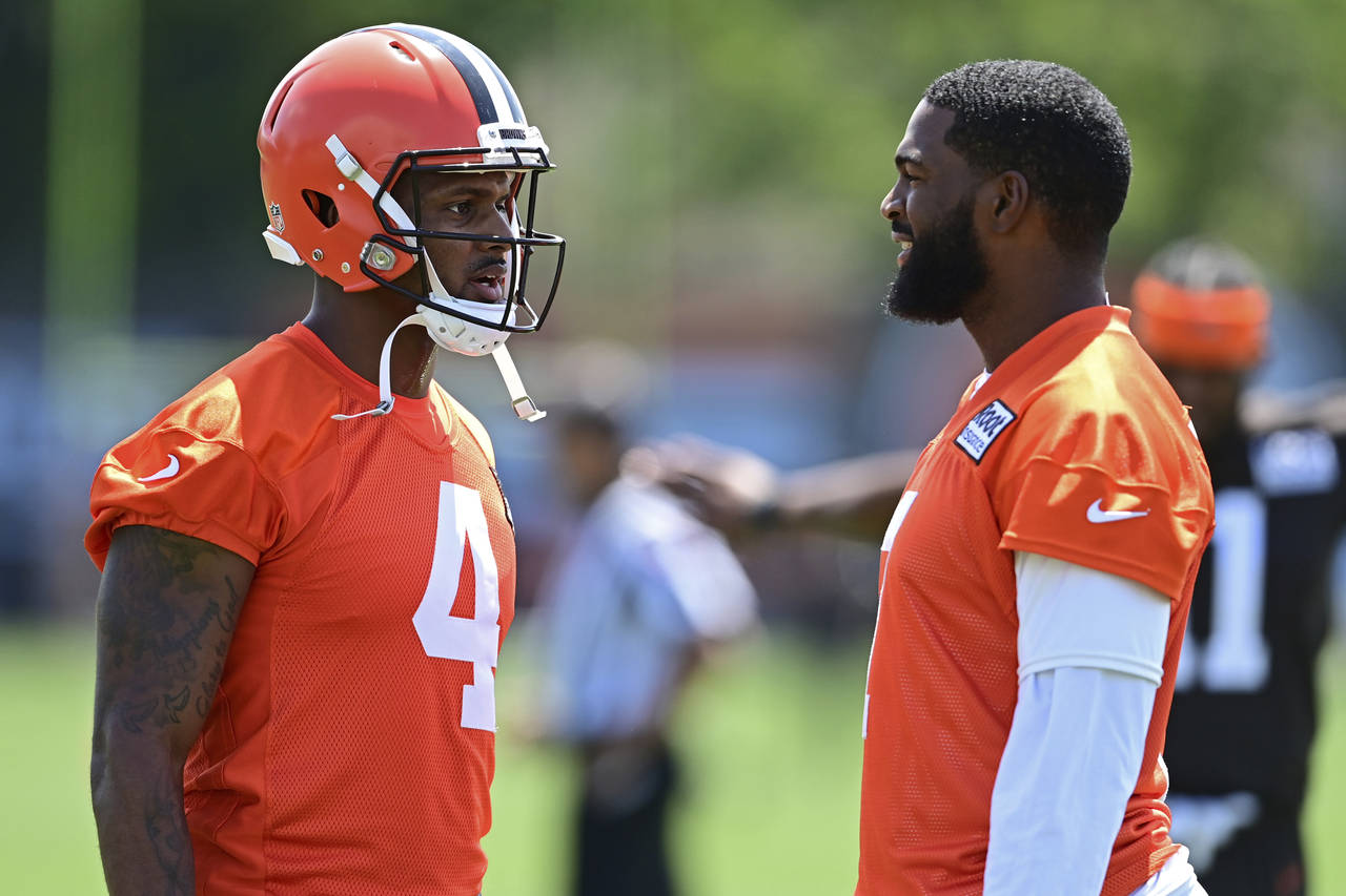 Cleveland Browns quarterbacks Deshaun Watson, left, and Jacoby Brissett talk before an NFL football...