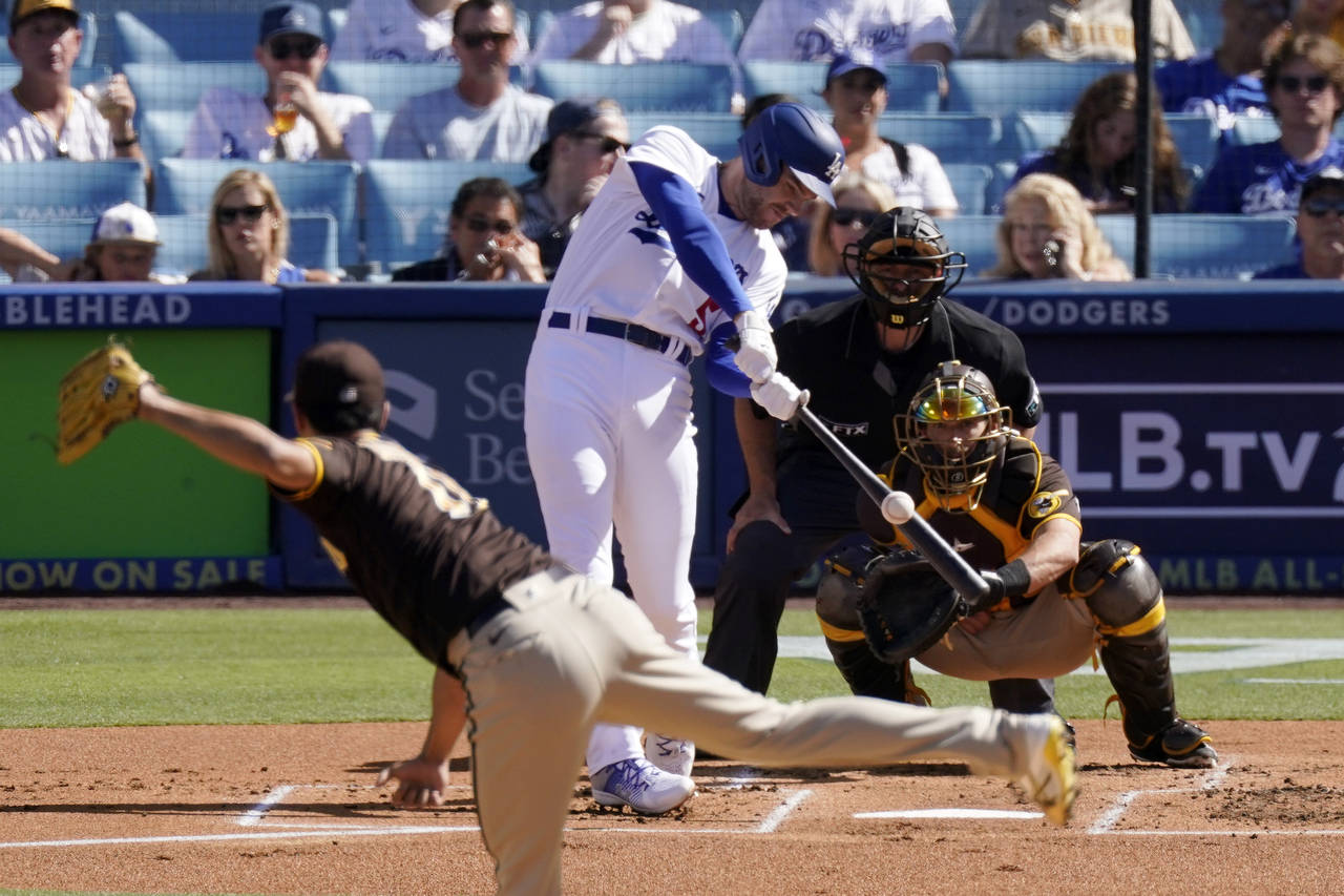 Los Angeles Dodgers' Freddie Freeman, second from left, hits a solo home run as San Diego Padres st...