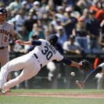 
              Houston Astros' Jose Altuve, right, slides in to score on a wild pitch as Seattle Mariners pitcher Ryan Borucki (30) attempts to tag him out during the eighth inning of a baseball game Saturday, July 23, 2022, in Seattle. (AP Photo/Ted S. Warren)
            