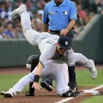 
              New York Yankees third baseman Josh Donaldson, top, falls over Baltimore Orioles' Cedric Mullins, bottom, on a pick off attempt at third during the first inning of a baseball game, Friday, July 22, 2022, in Baltimore. Mullins was safe. (AP Photo/Nick Wass)
            
