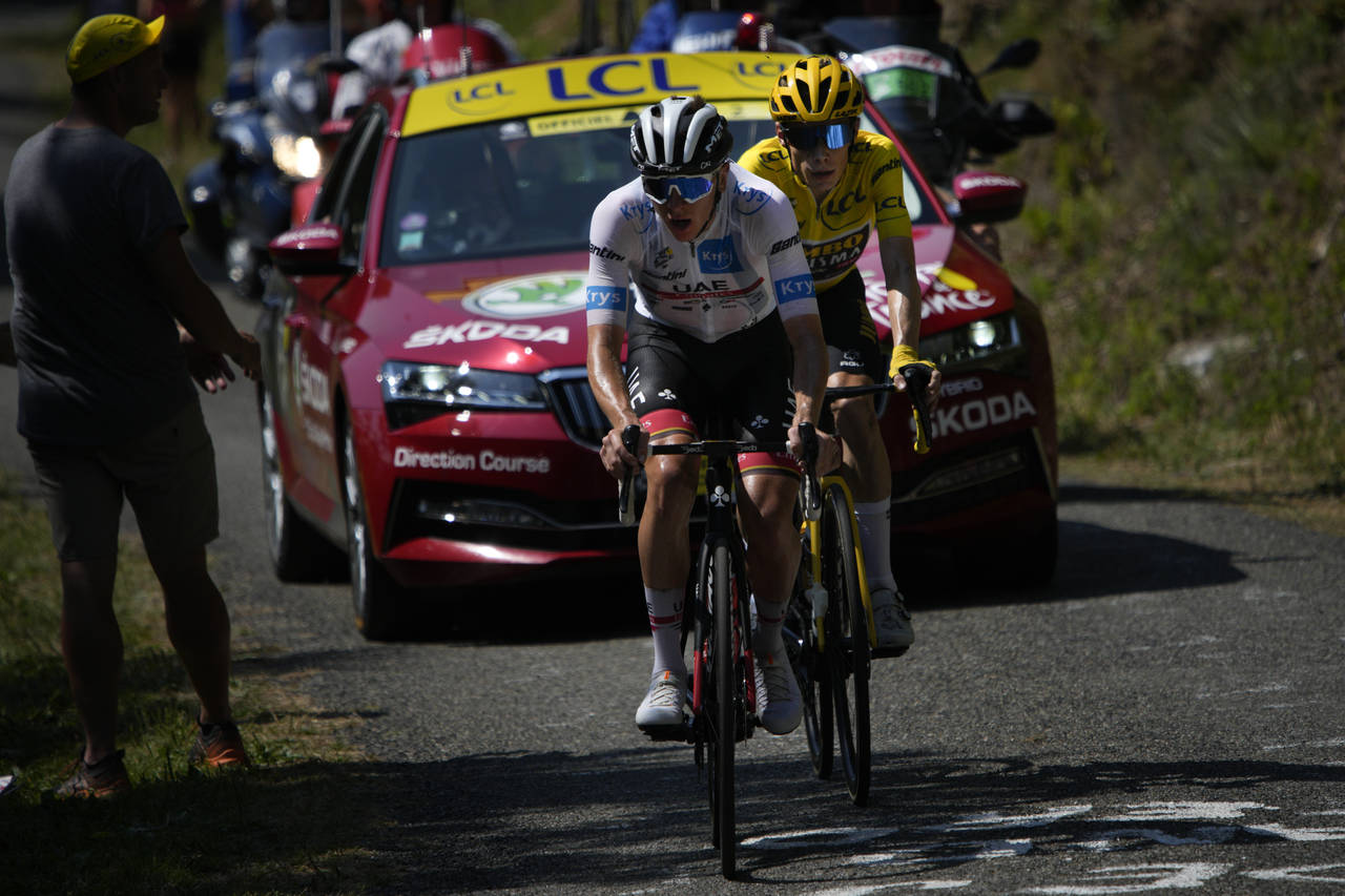 Slovenia's Tadej Pogacar, wearing the best young rider's white jersey, tries to break away from Den...