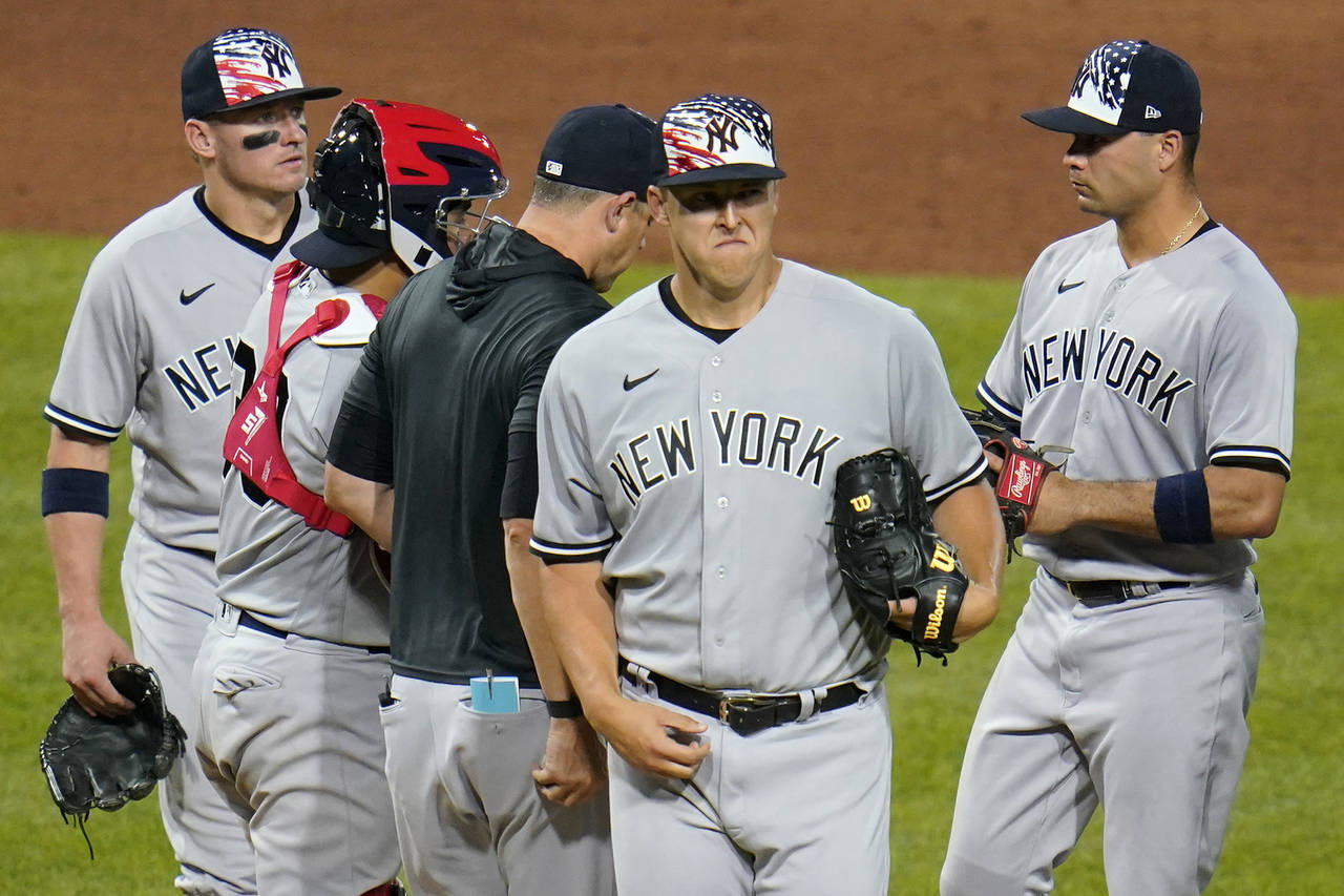 New York Yankees starting pitcher Jameson Taillon, front, walks off the mound after giving the ball...