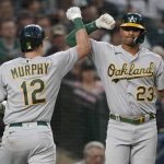 
              Oakland Athletics' Sean Murphy (12) is congratulated by Christian Bethancourt (23) after Murphy hit a solo home run against the Seattle Mariners during the seventh inning of a baseball game Friday, July 1, 2022, in Seattle. (AP Photo/Ted S. Warren)
            