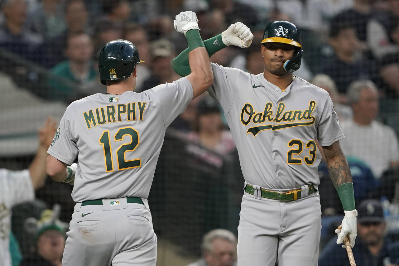 Oakland Athletics' Sean Murphy (12) is congratulated by Christian Bethancourt (23) after Murphy hit...
