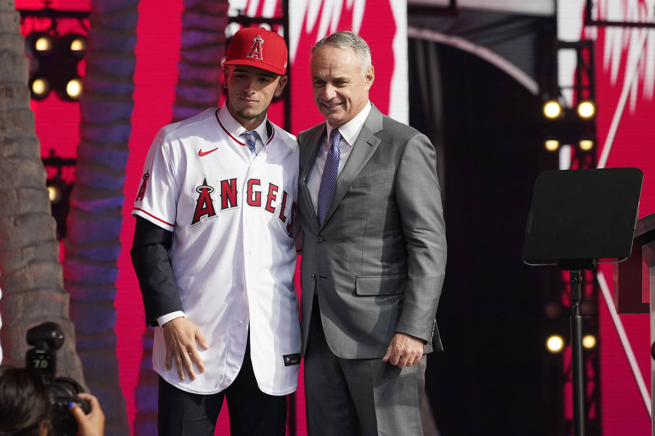 Zach Neto poses for photos with MLB Commissioner Rob Manfred after being selected by the Los Angele...