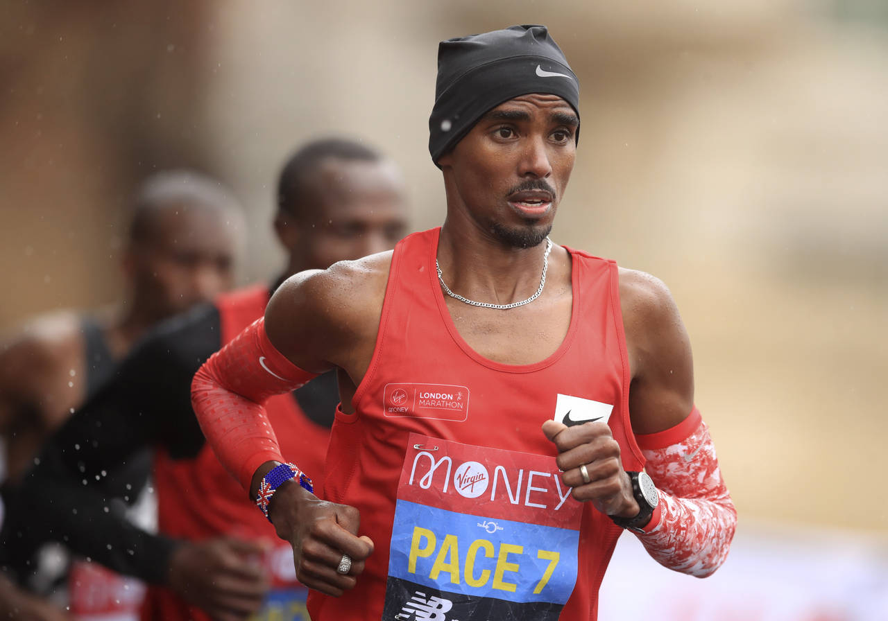 FILE - Britain's Mo Farah, right, runs as a pacemaker during the London Marathon in London, England...