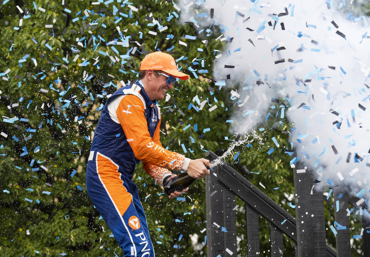 Scott Dixon, of New Zealand, celebrates with champagne in the Winners Circle after winning  an Indy...
