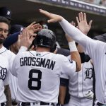
              Detroit Tigers' Robbie Grossman is greeted in the dugout after scoring on a sacrifice hit by Miguel Cabrera during the seventh inning of a baseball game against the Cleveland Guardians, Wednesday, July 6, 2022, in Detroit. (AP Photo/Carlos Osorio)
            