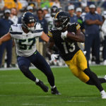 PITTSBURGH, PA - AUGUST 13: Miles Boykin #13 of the Pittsburgh Steelers runs up field after a catch under pressure from Cody Barton #57 of the Seattle Seahawks in the second quarter during a preseason game at Acrisure Stadium on August 13, 2022 in Pittsburgh, Pennsylvania. (Photo by Justin Berl/Getty Images)