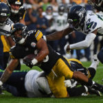 PITTSBURGH, PA - AUGUST 13: Jaylen Warren #30 of the Pittsburgh Steelers is wrapped up for a tackle by Poona Ford #97 of the Seattle Seahawks in the second quarter during a preseason game at Acrisure Stadium on August 13, 2022 in Pittsburgh, Pennsylvania. (Photo by Justin Berl/Getty Images)