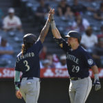 ANAHEIM, CALIFORNIA - AUGUST 17: Cal Raleigh #29 of the Seattle Mariners celebrates with his teammate J.P. Crawford #3 after hitting a two run home run against the Los Angeles Angels during the ninth inning at Angel Stadium of Anaheim on August 17, 2022 in Anaheim, California. (Photo by Michael Owens/Getty Images)