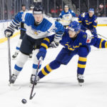 
              Sweden's Simon Edvinsson (7) and Finland's Roby Jarventie (13) race to the puck during the third period of a semifinal in the IIHF world junior hockey championships Friday, Aug. 19, 2022, in Edmonton, Alberta. (Jason Franson/The Canadian Press via AP)
            