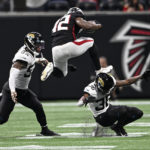 
              Atlanta Falcons running back Caleb Huntley (42) leaps over Jacksonville Jaguars cornerback Benjie Franklin (36) during the second half of an NFL football game, Saturday, Aug. 27, 2022, in Atlanta. (AP Photo/Danny Karnik)
            