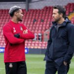 
              This image released by FX shows Dior Angus, left, and Ryan Reynolds in a scene from the docuseries "Welcome to Wrexham," which follows owners Reynolds and Rob McElhenney as they takeover the lower-league Welsh soccer team Wrexham AFC. (Patrick McElhenney/FX via AP)
            