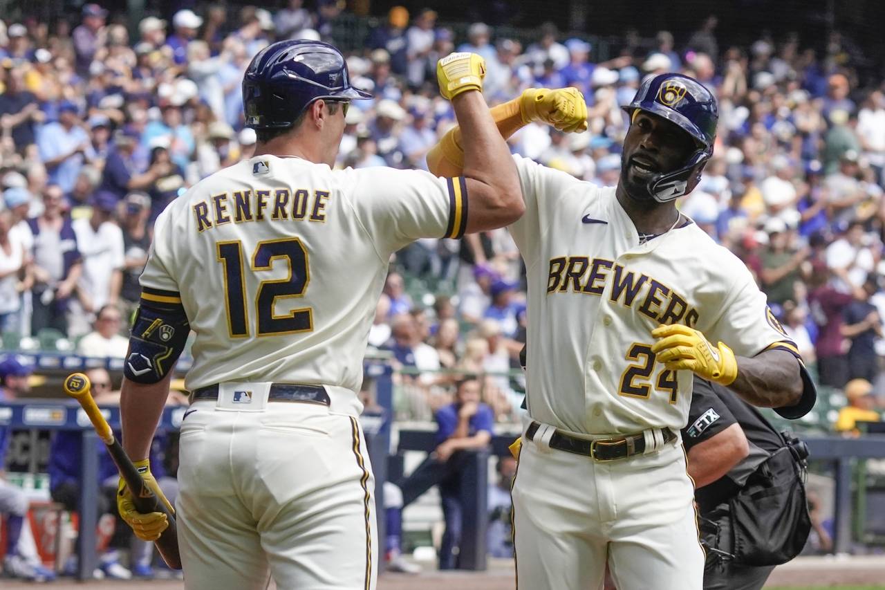 Milwaukee Brewers' Andrew McCutchen is congratulated by Hunter Renfroe after hitting a home run dur...