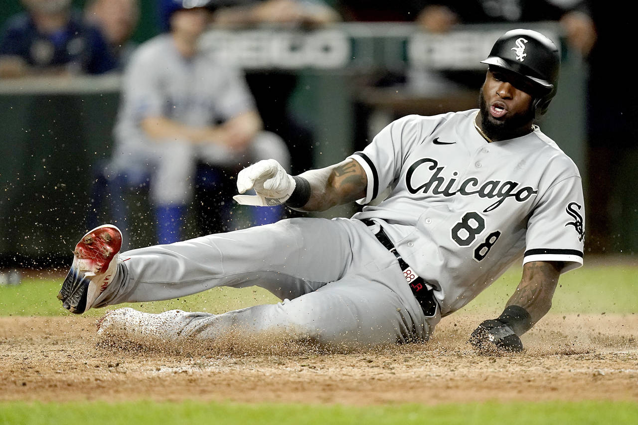 Chicago White Sox's Luis Robert slides home to score on a double by Gavin Sheets during the eighth ...