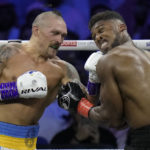 
              Britain's Anthony Joshua, right, takes a blow from Ukraine's Oleksandr Usyk during their world heavyweight title fight at King Abdullah Sports City in Jeddah, Saudi Arabia, Sunday, Aug. 21, 2022. (AP Photo/Hassan Ammar)
            