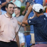 
              Scottie Scheffler, left, speaks with Xander Schauffele after thier round on the 18th green during the second round of the Tour Championship golf tournament at East Lake Golf Club, Friday, Aug. 26, 2022, in Atlanta. (AP Photo/Steve Helber)
            