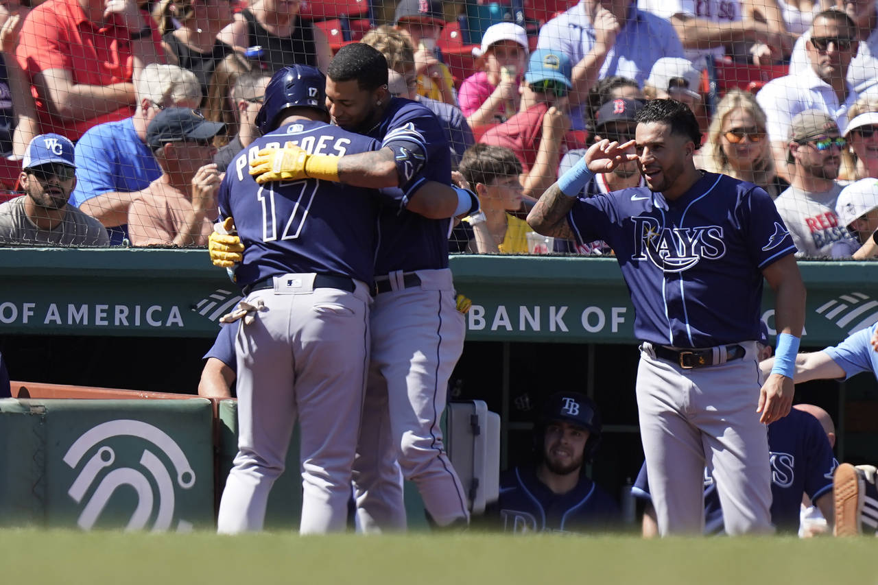 Tampa Bay Rays' Isaac Paredes, left, celebrates with Jose Siri, center, as he is welcomed to the du...