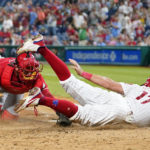 
              Philadelphia Phillies' Rhys Hoskins, right, is tagged out at home by Cincinnati Reds catcher Austin Romine after trying to score on a double by J.T. Realmuto during the seventh inning of a baseball game, Wednesday, Aug. 24, 2022, in Philadelphia. (AP Photo/Matt Slocum)
            
