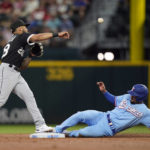 
              Chicago White Sox second baseman Leury Garcia (28) throws to first base to get out Texas Rangers' Corey Seager for a double play over Rangers' Marcus Semien, right, during the first inning of a baseball game in Arlington, Texas, Sunday, Aug. 7, 2022. (AP Photo/LM Otero)
            