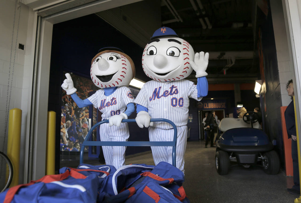 FILE - New York Mets mascots Mr. and Mrs. Met pose for pictures with the team's equipment before it...