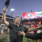 
              FILE - Georgia head coach Kirby Smart, center, is greeted by his wife Mary Beth Smart, right, after a win over Florida in an NCAA college football game, Saturday, Oct. 30, 2021, in Jacksonville, Fla. Georgia is No. 3 in The Associated Press preseason college football poll, released Monday, Aug. 15, 2022.  (AP Photo/Phelan M. Ebenhack, File)
            