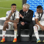 
              Real Madrid's head coach Carlo Ancelotti, centre, speaks with his players Casemiro, right, and Eder Militao after winning the UEFA Super Cup final soccer match between Real Madrid and Eintracht Frankfurt at Helsinki's Olympic Stadium, Finland, Wednesday, Aug. 10, 2022. Real Madrid won 2-0. (AP Photo/Antonio Calanni)
            