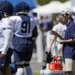 
              Peter Engler, right, a football research assistant, observes defensive players on Aug. 3, 2022 during a training camp practice at the team's training facility in Renton, Wash. Coming off their worst season in head coach Pete Carroll's tenure, the Seahawks aimed to supplement their analytics staff — that before this season was on the smaller side compared to other NFL teams — with the hiring of Engler, and senior football research analyst Becca Erenbaum, who will be called upon to take various data streams data and create a statistical analysis of situations. (AP Photo/Ted S. Warren)
            