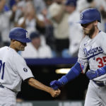 
              Los Angeles Dodgers' Cody Bellinger (35) celebrates with third base coach Dino Ebel (91) after hitting a solo home run during the ninth inning of a baseball game against the Kansas City Royals Saturday, Aug. 13, 2022, in Kansas City, Mo. The Dodgers won 13-3. (AP Photo/Charlie Riedel)
            