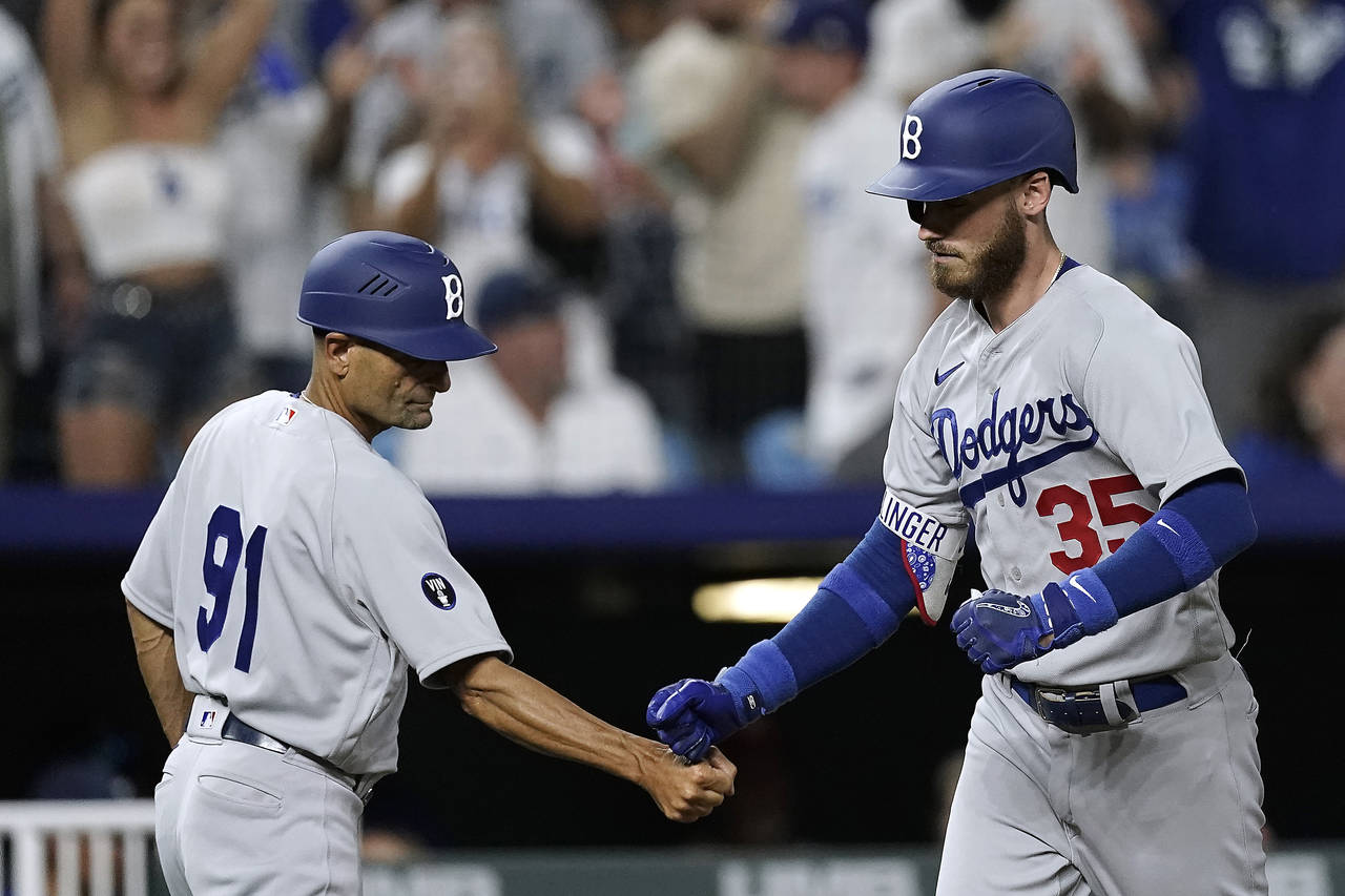 Los Angeles Dodgers' Cody Bellinger (35) celebrates with third base coach Dino Ebel (91) after hitt...