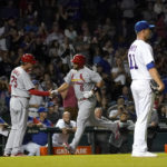 
              St. Louis Cardinals' Albert Pujols (5) is congratulated by third base coach Ron 'Pop' Warner after Pujols' 693rd career home run off Chicago Cubs starting pitcher Drew Smyly, right, during the seventh inning of a baseball game Monday, Aug. 22, 2022, in Chicago. (AP Photo/Charles Rex Arbogast)
            