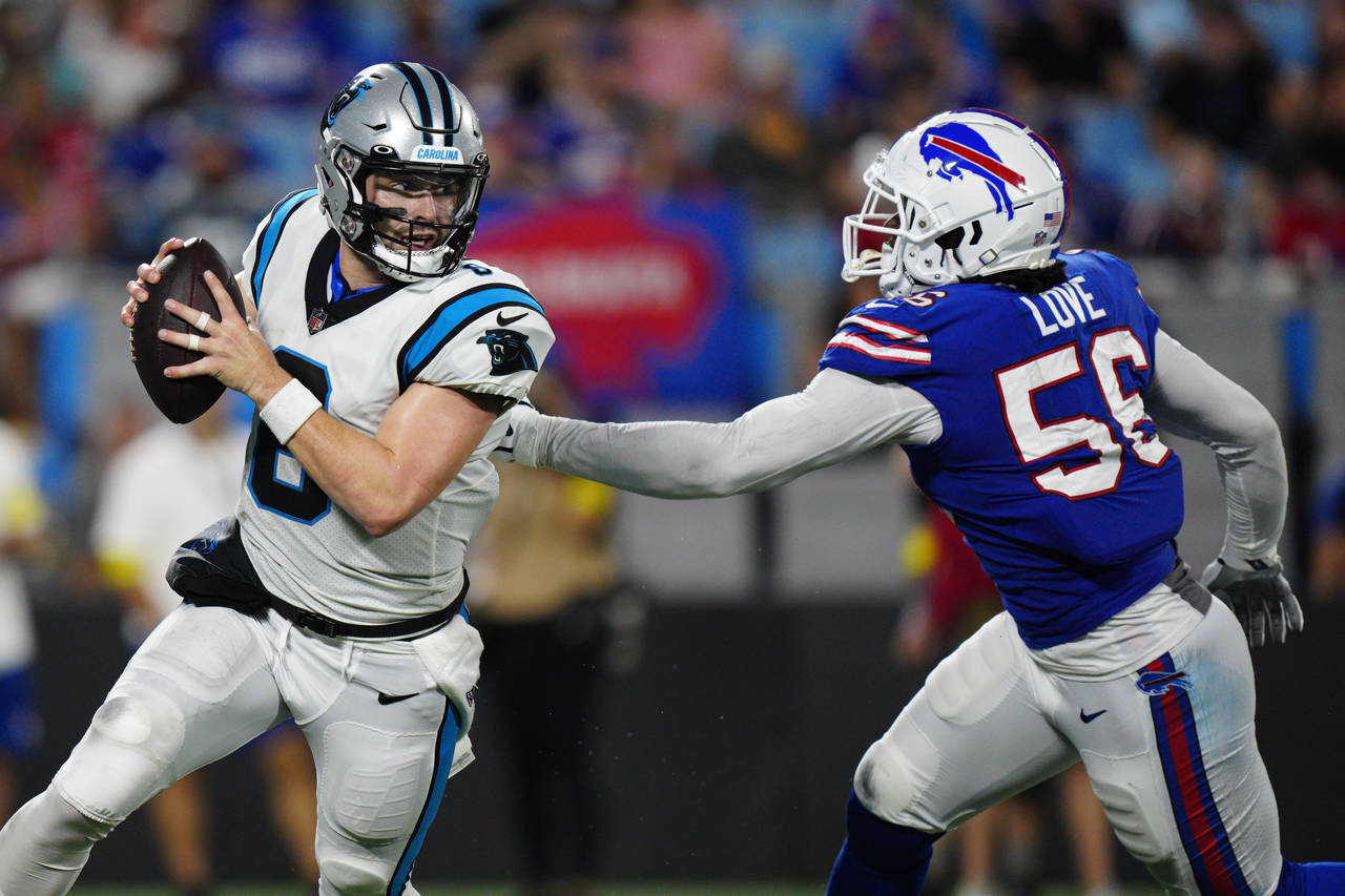 Carolina Panthers quarterback Baker Mayfield breaks away from Buffalo Bills defensive end Mike Love...