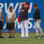 
              Unidentified members of the Cleveland Guardians grounds crew wait with Guardians manager Terry Francona, second from right, and Chicago White Sox manager Tony LaRussa, right, for umpires as they inspect the condition of Progressive Field before a baseball game in Cleveland, Sunday, Aug. 21, 2022. (AP Photo/Phil Long)
            