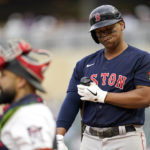 
              Boston Red Sox's Rafael Devers reacts alongside Minnesota Twins catcher Sandy Leon while batting during the first inning of a baseball game Monday, Aug. 29, 2022, in Minneapolis. (AP Photo/Abbie Parr)
            